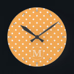 Horloge Ronde Mongram de Custom. Orange et blanc Polka Dot.<br><div class="desc">A customizable monogram initial letter on a background of an orange and white polka dot pattern. The letter can be personalized.</div>