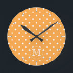 Horloge Ronde Mongram de Custom. Orange et blanc Polka Dot.<br><div class="desc">A customizable monogram initial letter on a background of an orange and white polka dot pattern. The letter can be personalized.</div>