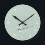 Horloge Ronde Monogramme Initiales Noms Élégant Script Sage Vert<br><div class="desc">Les Initiales Monogrammes Nouveaux Noms Élégant Script Nouveau Sage Vert. La typographie romantique avec les initiales et les noms des couples que vous pouvez facilement personnaliser.</div>