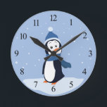 Horloge Ronde Penguin (with numbers)<br><div class="desc">A penguin wearing a blue hat and scarf stands in the snow and watches the snowflakes fall. This design is available on multiple products including shirts,  mugs,  pillows,  and more! It can be customized or personalized by adding your own text or images!</div>