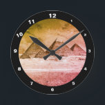 Horloge Ronde Pyramides et désert, vintage Caire / Égypte ancien<br><div class="desc">CLOCKS - Pyramides antiques en Egypte art vintage. La vue sur toutes les pyramides en ligne souligne la magnificence de la région. Le sommet de la Grande Pyramide est toujours recouvert de bureaux en pierre déco plate et imaginons, quelle vue extraordinaire elle a dû avoir à l'époque de leur apogée....</div>