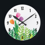 Horloge Ronde Tulipes colorées et végétation verte<br><div class="desc">Cette horloge comporte une conception fraîche de ressort avec les tulipes oranges,  roses et pourpres et la végétation verte. L'horloge est parfaite pour ajouter que "regard de ressort" à votre maison et également ferait un grand cadeau du jour de mère.</div>