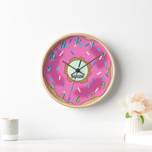 Horloge Un arc-en-ciel de couleurs, un beignet rose avec u