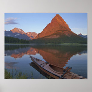 Houten kajak in Swiftcurrent Lake bij zonsopgang i Poster