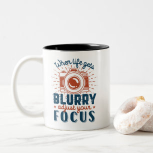 Inspirerend fotografie-citaat past uw focus aan tweekleurige koffiemok