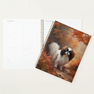 Japanese Chin dans les feuilles d'automne tombent 