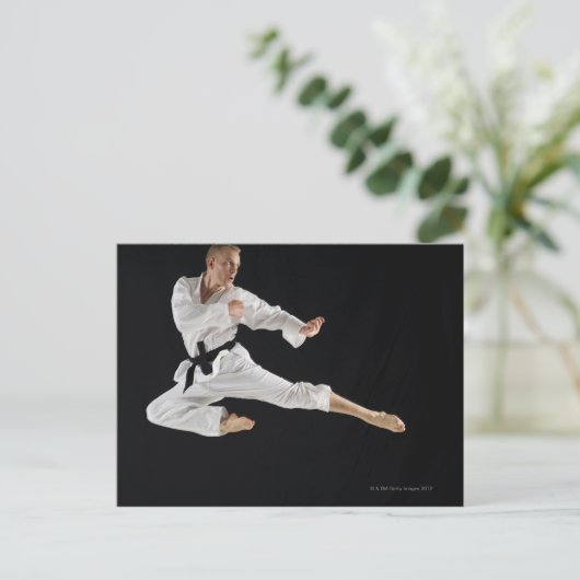 Jong man dat karate schoppen in zwart briefkaart (Staand voorkant)