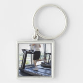 Jong man dat op een loopband in de gezondheidsclub sleutelhanger (Voorkant)