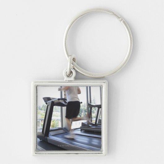 Jong man dat op een loopband in de gezondheidsclub sleutelhanger (Voorkant)