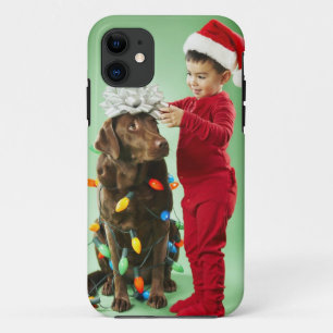 Jonge jongen die kerstverlichting rond een hond wi iPhone 11 hoesje
