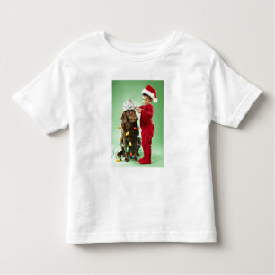 Jonge jongen die kerstverlichting rond een hond wi kinder shirts