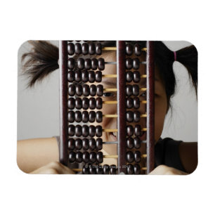 Jonge vrouw die door abacus paait. magneet