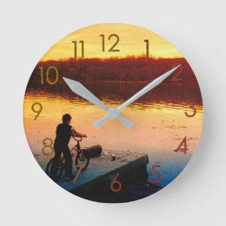 Jongen op fiets bij zonsondergang wandklok ronde klok