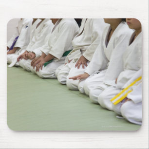 Judospeler van het kind gaat zitten tot één lijn muismat