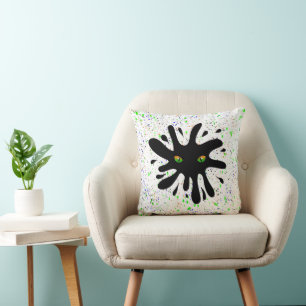 Kat Eyes kijkt uit naar een zwart blok Kussen