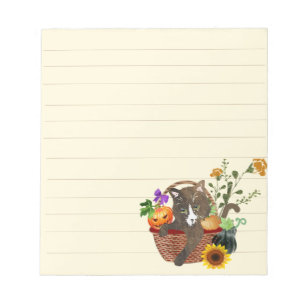 Kat in een mand met pompoen en bloemen notitieblok