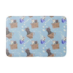 Katten in doos en melkdruppels op blauw badmat
