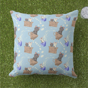 Katten in doos en melkdruppels op blauw buitenkussen