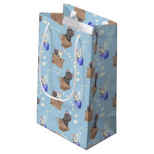 Katten in doos en melkdruppels op blauw klein cadeauzakje