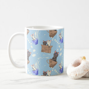 Katten in doos en melkdruppels op blauw koffiemok