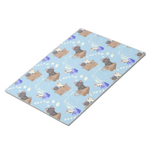 Katten in doos en melkdruppels op blauw notitieblok