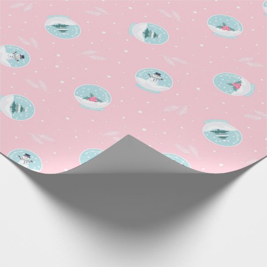 kerstpatroon van magische sneeuwballen op roze cadeaupapier (Hoek)
