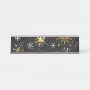 Kerstsneeuwvlokken in goud op een zwarte achtergro bureau naambordje