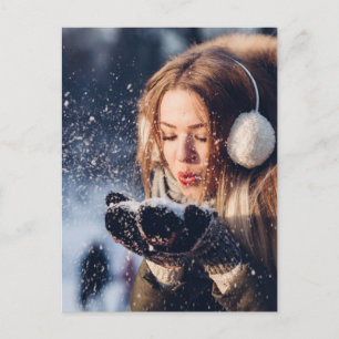 Kerstwintermeisje blaast sneeuw in haar hand briefkaart