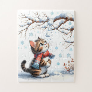 Kitten kijkt naar vallende sneeuw vanaf tak legpuzzel
