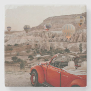 Klassieke rode auto die warme luchtballonnen kijk stenen onderzetter