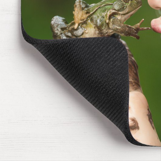 Klein meisje dat een modderige kikker kust muismat (Hoek)