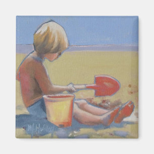 Kleine jongen die in het zand speelt met een schop magneet