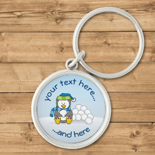 Kleine pinguïn die zit met sneeuwballen sleutelhanger