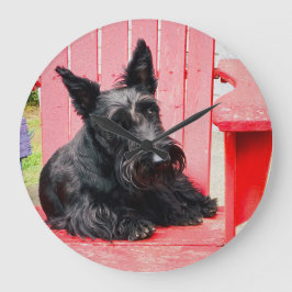 Kleine Scottie in een grote rode stoel Klok
