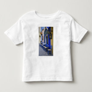 Kleurrijke blauwe deuropening en zijgevel van oud kinder shirts