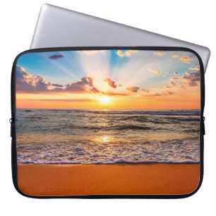 Kleurrijke oceaanstrandzonsopgang met diepe blauwe laptop sleeve
