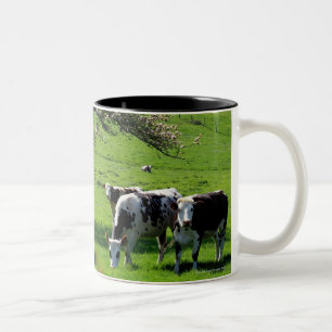 Koe onder bloeiende appelbomen in Normandië Tweekleurige Koffiemok