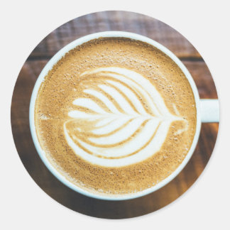 Koffielatte met bladschuim op hout ronde sticker