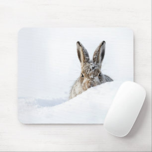 Konijn dat over een sneeuwbank gluurt muismat