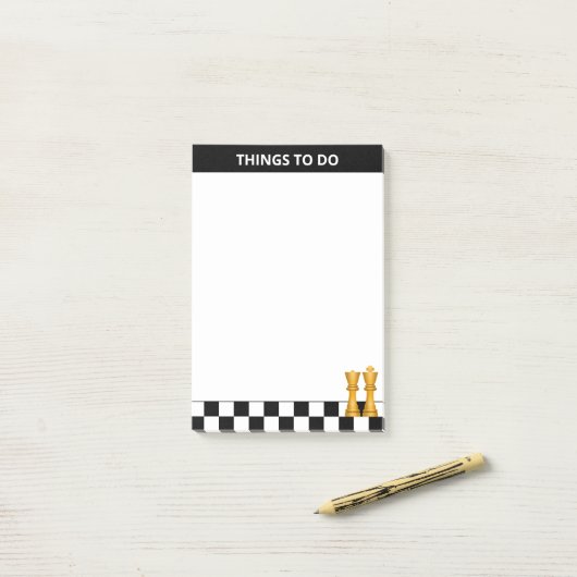 Koningin & koning over zwarte en witte schaafdinge post-it® notes (Op bureau)