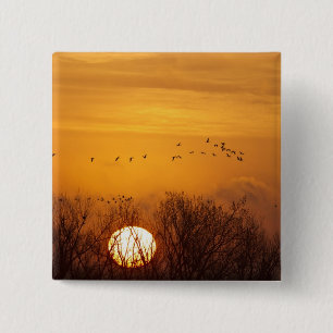 Kraanvogels als silhouet tegen opkomende zon vierkante button 5,1 cm