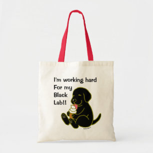 Labrador noir léchant le sac fourre-tout à crèm