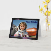 L'astronaute lève la carte d'anniversaire du garço (Fleur jaune)