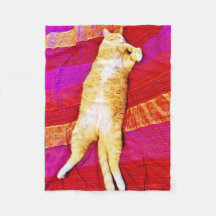 Le chaton orange dort sur une couverture en toison