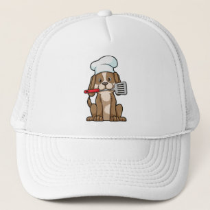 Le chien cuisinier avec le casquette et la spatule