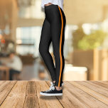 Leggings noirs élégants avec bande latérale orange<br><div class="desc">Ces leggings noirs élégants et confortables avec une bande orange audacieuse sont l'ajout parfait à votre garde-robe décontractée. Conçues pour la forme et la mode, elles offrent un look flatteur et attrayant. Que vous vous rendiez à la salle de sport ou aux courses de course, ces leggings offrent un mélange...</div>