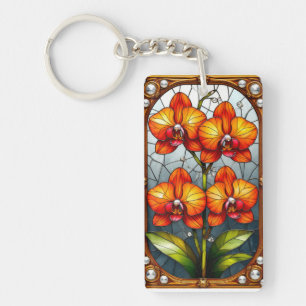 Levendige oranje orchideeën in decoratieve gouden sleutelhanger
