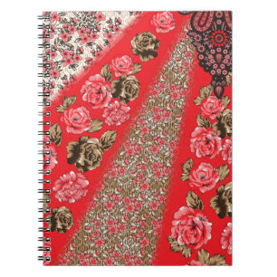 Levendige rode stof met ingewikkelde bloemen en notitieboek