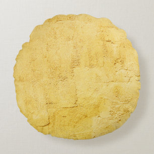 lichtgele abstracte getextureerde pleister op de w rond kussen
