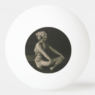 Lief arm meisje zit met gekruiste benen pingpongballen
